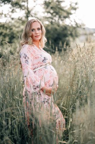 babybauch shooting im feld mit rosa kleid