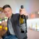 winzer mit weinflasche in der hand